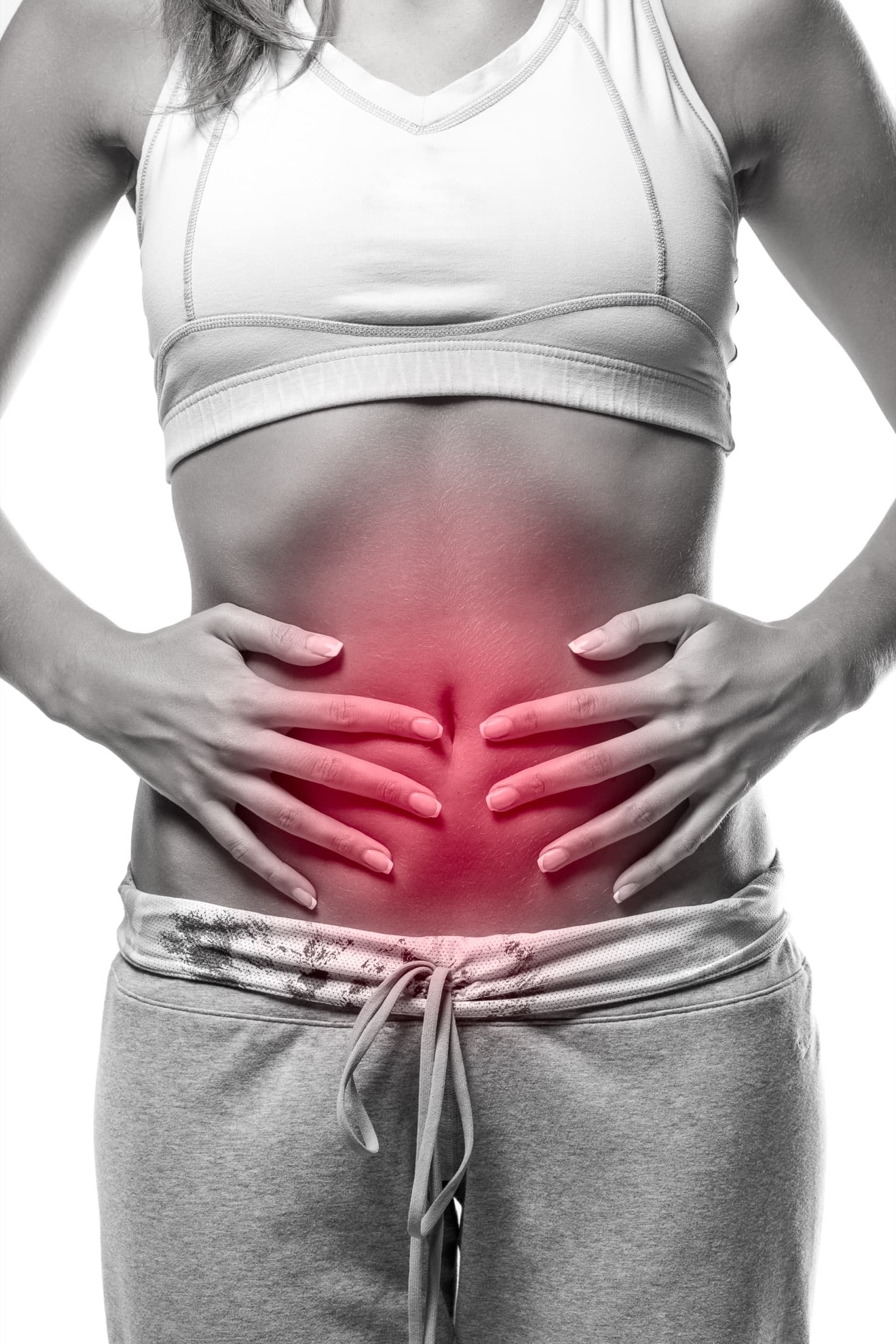 A woman holding both hands over her lower abdomen
